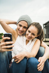 Glückliches junges Paar macht ein Selfie mit Smartphone - UUF001089