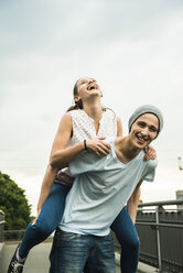 Young man giving his girlfriend a piggyback - UUF001090