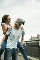 Young man giving his girlfriend a piggyback - UUF001091