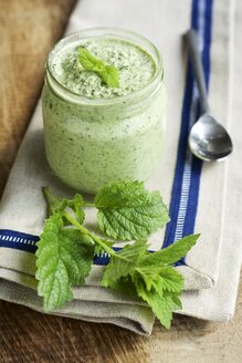 Ein Glas hausgemachtes Zitronenmelissenpesto mit frischen Melissenblättern (Melissa officinalis) - HAWF000324