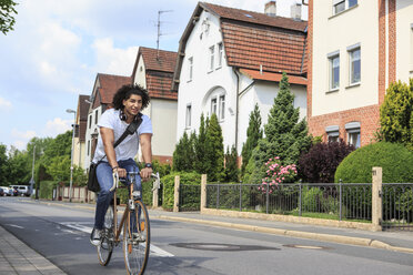 Young male student with headphones driving on a racing cycle - VTF000295