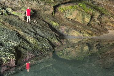 New Zealand, Golden Bay, Puponga, boy in a cave with pool of water - SHF001487