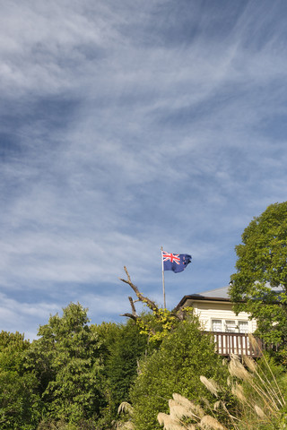 Neuseeland, Nelson, Villa mit neuseeländischer Flagge auf den Hügeln, lizenzfreies Stockfoto