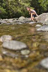 New Zealand, Nelson, Maitai Valley, girl balancing on rocks of Maitai River - SHF001488