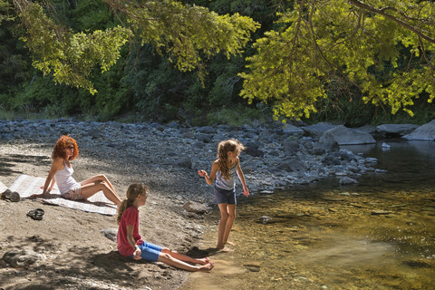 Neuseeland, Nelson, Maitai Valley, Familie ruht sich am Ufer des Maitai River aus, lizenzfreies Stockfoto