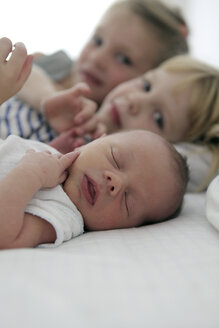 Porträt eines neugeborenen Jungen und seiner beiden Schwestern im Hintergrund - SAF000014