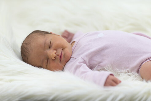Neugeborenes Mädchen schläft auf einem Schafsfell - ROMF000012