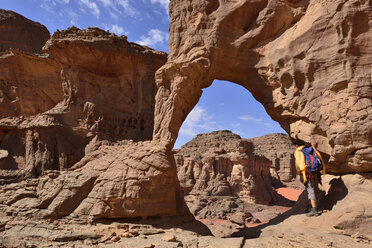 Afrika, Algerien, Sahara, Tassili N'Ajjer National Park, Tassili Tadrart, Cirque, Frau schaut durch einen natürlichen Bogen - ES001231