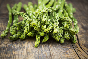 Bunch of green asparagus, Asparagus officinalis, lying on dark wood - LVF001459