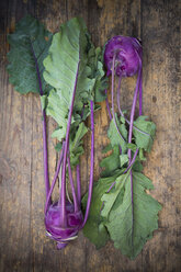 Two blue turnip cabbages, Brassica oleracea var. gongylodes L. on dark wood, elevated view - LVF001453