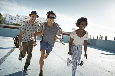 Friends playing urban golf in empty swimming pool - VV000142