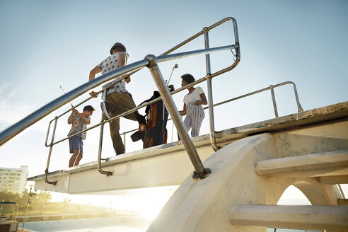 Freunde spielen Urban Golf auf dem Highboard eines Swimmingpools - VV000123