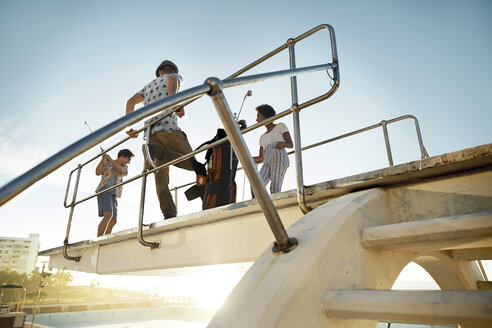 Friends playing urban golf on highboard of a swimming pool - VV000123