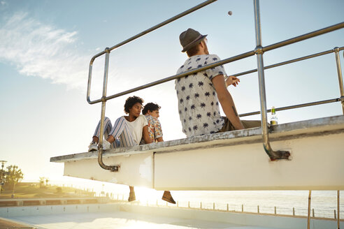 Urban golfers sitting on highboard of a swimming pool - VV000128