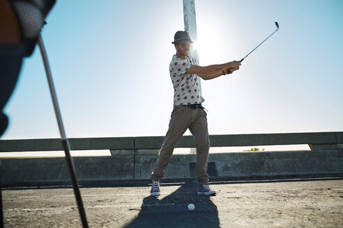 Man playing urban golf on street - VVF000131