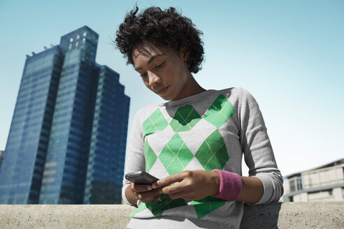 Young woman looking at cell phone outdoors - VVF000134