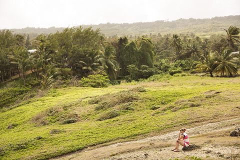 Karibik, Barbados, Bathsheba, Frau sitzend in ländlicher Landschaft, lizenzfreies Stockfoto