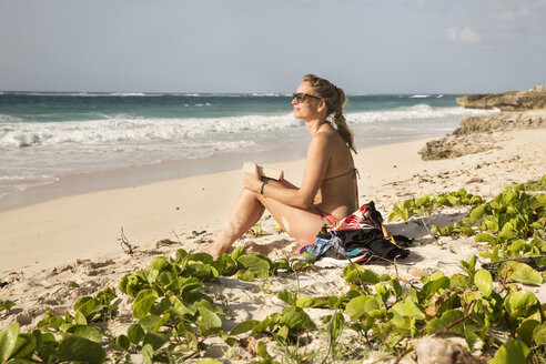 Karibik, Barbados, Frau sitzt am Strand - SKF001559