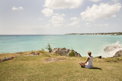 Karibik, Barbados, Frau sitzt an der Küste - SKF001560