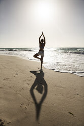 Caribbean, Barbados, Silver Sands beach, woman practicing yoga - SKF001563