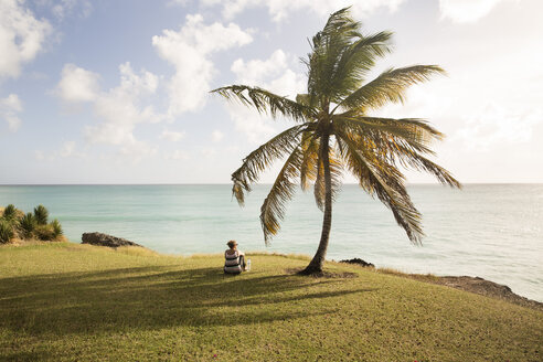 Karibik, Barbados, Frau sitzt an der Küste - SKF001568