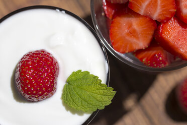 Strawberries in a glass and strawberry with yogurt in a glass, garnished with lemon balm - YFF000181