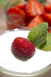 Strawberries in a glass and strawberry with yogurt in a glass, garnished with lemon balm - YFF000183