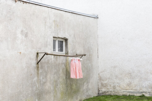 Deutschland, düsterer Hinterhof mit Kinderkleidern an der Kleiderstange - DRF000695