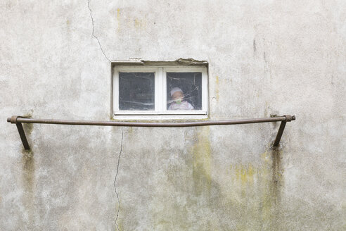 Deutschland, Puppe sitzt hinter dem Fenster einer Garage - DR000697