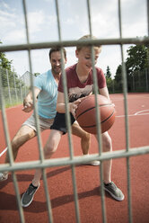 Germany, Mannheim, Father and son playing basket ball - UUF001170