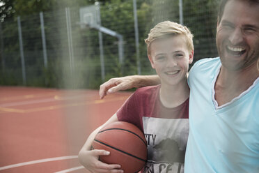 Germany, Mannheim, Father and son playing basket ball - UUF001183