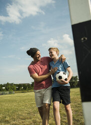 Germany, Mannheim, Father and son playing soccer - UUF001123