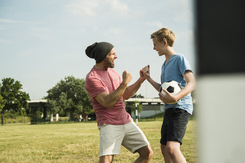 Germany, Mannheim, Father and son playing soccer - UUF001125