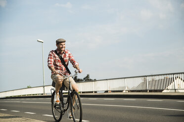 Deutschland, Mannheim, Mann mit Mütze fährt Fahrrad - UUF001172