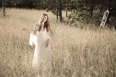 Porträt eines Mädchens im weißen Kleid auf einer Wiese im Gegenlicht - FCF000269