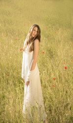 Porträt eines Mädchens im weißen Kleid auf einer Wiese stehend - FCF000270