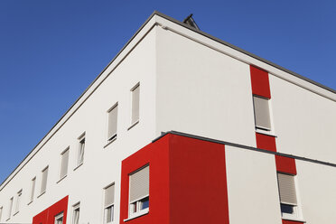 Germany, Cologne Widdersdorf, red-white facade of multi-family house - GWF003549