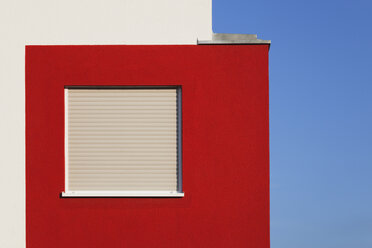 Germany, Cologne Widdersdorf, red-white facade of multi-family house with closed window - GWF003550