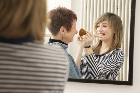 Germany, Berlin, Mother and daughter applying make up stock photo