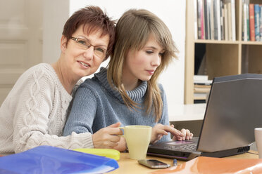 Germany, Berlin, Mother and daughter using laptop - MMFF000029