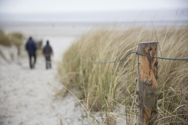 Deutschland, Niedersachsen, Ostfriesland, Langeoog, zwei Personen auf dem Weg zum Strand - JATF000747