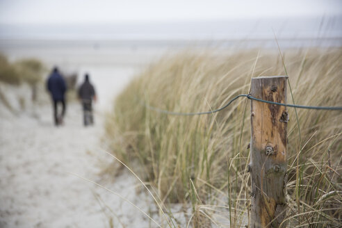Germany, Lower Saxony, East Friesland, Langeoog, two people walking to the beach - JATF000747