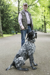 Senior man with his German Shorthaired Pointer in city park - JATF000734