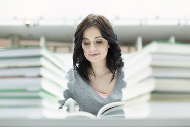 Student in einer Universitätsbibliothek beim Lesen eines Buches - WESTF019637