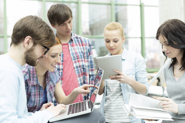 Studenten in einer Universitätsbibliothek mit digitalem Tablet und Laptop - WESTF019566