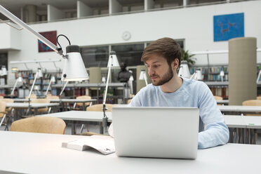 Student mit Laptop in einer Universitätsbibliothek - WESTF019567