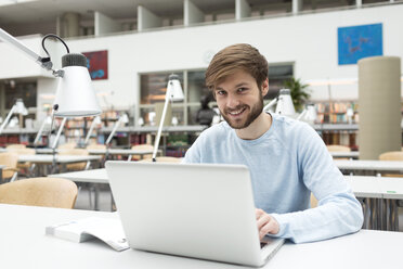 Student mit Laptop in einer Universitätsbibliothek - WESTF019568