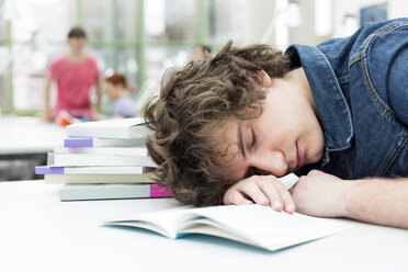 Erschöpfter Student schläft in einer Universitätsbibliothek - WESTF019656