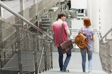 Zwei Studenten in einer Universitätsbibliothek, die eine Treppe hinuntergehen - WESTF019612