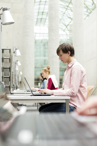 Studenten benutzen Laptops in einer Universitätsbibliothek, lizenzfreies Stockfoto